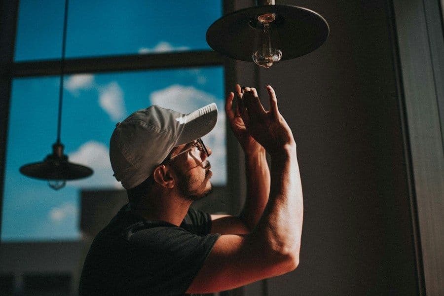 Electrician installing a pendant lamp on the ceiling